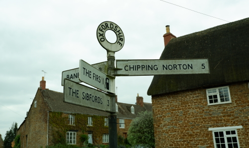 This image: a classic Oxfordshire signpost in Hook Norton
							 			pointing to Chipping Norton and Banbury.
		 							 The map: The map shows a dotted line around the site boundary,
									 with the Hook Norton Conservation Area highlighted in a pale
									 brown to the south of the site and throughout the village.
									 Several nearby facilities to the site are labelled
		 							 on the map.